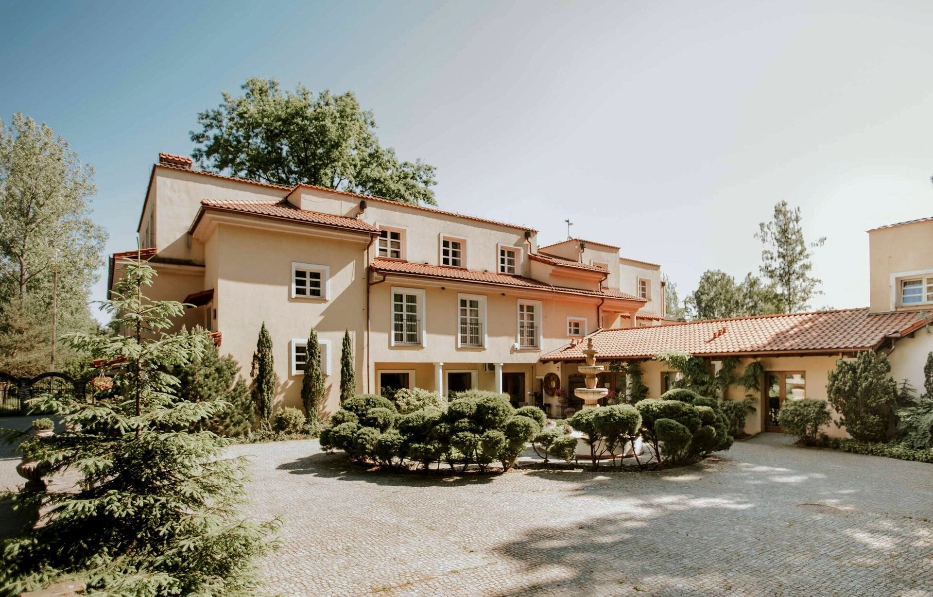 Villa Toscana – dziedziniec z fontanną w otoczeniu zieleni